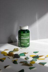 AfterCoweed supplement bottle with decorative leaves in dramatic lighting.